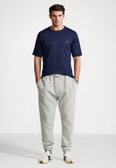 Navy cotton t-shirt with short sleeves and a round neck, paired with light grey sweatpants featuring an elastic waistband and cuffs.