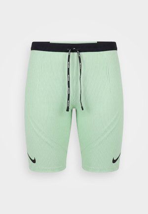 Shorts Nike côtelés vert clair avec taille noire et cordon, avec logos Nike swoosh noirs sur chaque jambe.