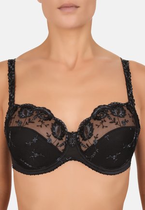 Soutien-gorge en dentelle noire avec des motifs floraux brodés, des bonnets en mesh transparent et des bretelles décoratives à bords festonnés. Support avec armatures inclus.
