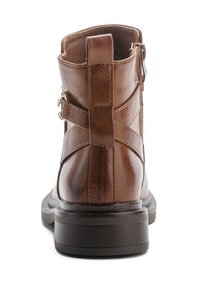 Bottine en cuir marron avec une finition lisse, fermeture éclair sur le côté et détail de boucle. Dotée d'une semelle en caoutchouc noir robuste pour une meilleure adhérence.