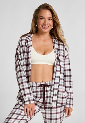 Rode en witte geruite flanellen blouse met lange mouwen, met een ontspannen pasvorm. Gecombineerd met bijpassende geruite broek en een witte geribbelde bralette.
