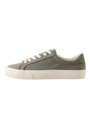 Niski sneaker z oliwkowo-zieloną cholewką z płótna, białymi sznurówkami i grubą białą gumową podeszwą, widziany z boku na białym tle.