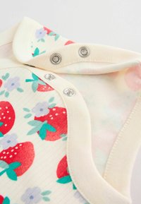 Body niemowlęce z kremowymi lamówkami, metalowymi zatrzaskami oraz wzorem czerwonych truskawek i fioletowych kwiatów na kremowym tle.