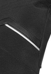 Schwarzer Stoff mit einem strukturierten Lederakzent, weißen Pipings und sichtbaren Nähten in einem diagonalen Muster.