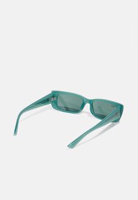 Ochelari de soare dreptunghiulari teal cu lentile întunecate, ramă din plastic elegantă, brațe late și un mic accent cu logo pe o parte.