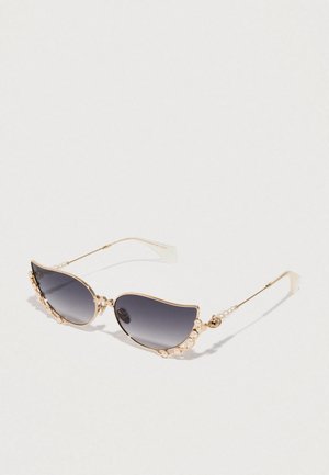 Sunglasses ve tvaru kočičích očí s tmavě šedými skly, zlatým kovovým rámem a dekorativními perlovými akcenty po stranách. Hladký povrch a unikátní tvar.