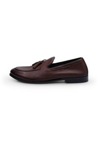 Ruskeat nahka loaferit, joissa on sileä pinta, koristeellinen ommelkuvio ja tupsuaksentit. Musta pohja, hieman kärjekäs muoto.