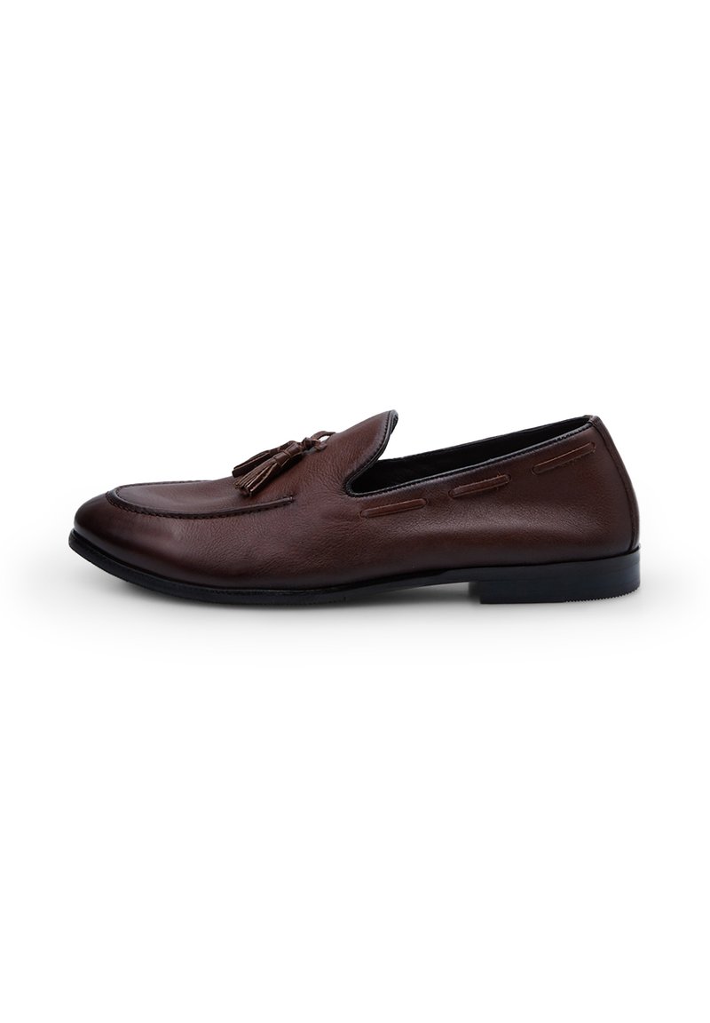 Ruskeat nahka loaferit, joissa on sileä pinta, koristeellinen ommelkuvio ja tupsuaksentit. Musta pohja, hieman kärjekäs muoto.