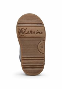 Suola in gomma marrone con superficie testurizzata e scanalature orizzontali. Presenta il logo "Naturino" impresso nella zona del tallone.