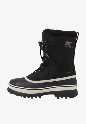 Black waterproof winter boot with a textured upper, faux fur lining, chunky rubber sole, and silver hardware accents. Features Sorel logo.