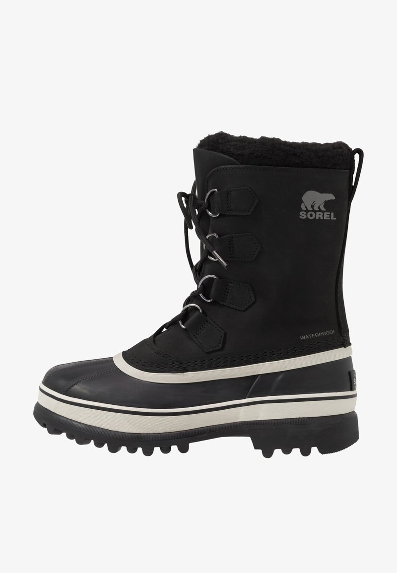 Botas de invierno impermeables negras con parte superior texturizada, forro de piel sintética, suela de goma gruesa y acentos de hardware plateado. Presenta el logo de Sorel.