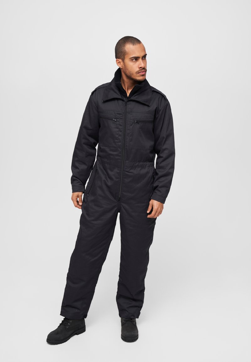 Black jumpsuit featuring a zip front, long sleeves, and two chest pockets. Material appears durable with a smooth texture and elastic waistband.