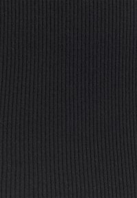 Černá žebrovaná látka s vertikálními pruhy, která má měkkou strukturu a elastické vlastnosti. Vhodná pro různé oděvní aplikace.