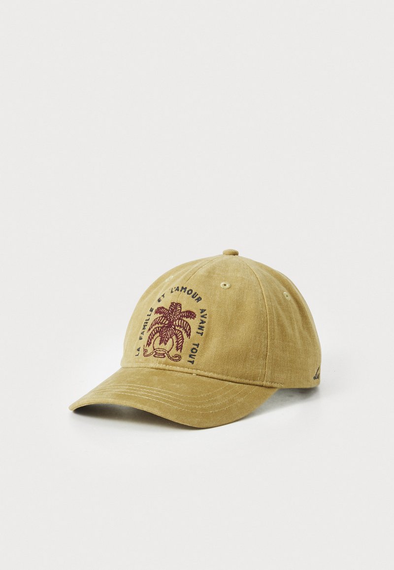 Yellow cotton cap with a rounded crown, curved brim, and embroidered maroon palm tree design. Text reads: "La famille et l'amour avant tout."