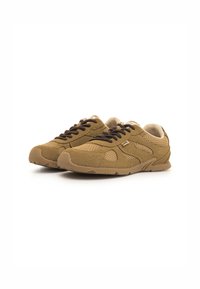 Zapatillas deportivas marrones hechas de malla y tela texturizada, con cordones de color marrón oscuro y una suela de goma flexible con agarres de tracción.