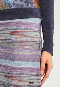 Abito lavorato a maglia multicolore con righe orizzontali blu, viola e grigie. Maniche lunghe con dettagli testurizzati e un accento con logo metallico.