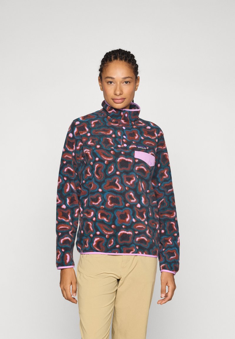 Fleece-pullover i mørkt mønster med rosa og teal-detaljer, høy krage og en lomme foran med trykknapp. Glatt tekstur.