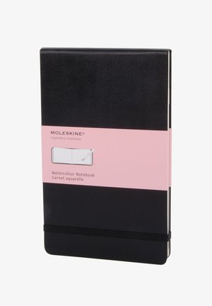Quaderno acquerello Moleskine nero con etichetta rosa, chiusura con elastico e piccola illustrazione di pennello acquerello sulla banda frontale.