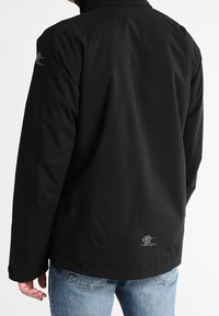 Czarna wodoodporna kurtka z wysokim kołnierzem, z logo na lewym ramieniu oraz wyszywanym detalem na dolnej części pleców.