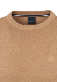 Beige gestrickter Pullover mit Rundhalsausschnitt, der ein dezentes gesticktes Logo und eine strukturierte Optik aufweist. Ungefüttertes Innenfutter mit einem blauen Akzentstreifen.