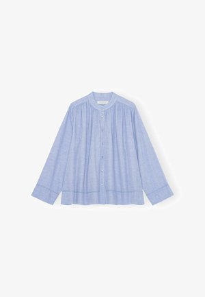 Helehall sinine pikkade varrukatega pluus ümarate kraega, ees nööpidega ja peente voldikute jaotusega rinna ja õlgade kohal.