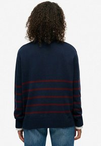 Granatowy sweter dzianinowy z czerwonymi poziomymi paskami, o luźnym kroju, z ribbingowanymi mankietami i hemem, z wysokim dekoltem i miękką teksturą.