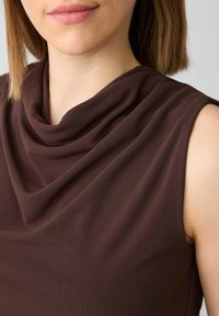 Top senza maniche marrone con scollatura drappeggiata. Tessuto morbido e liscio con una leggera lucentezza, che presenta una silhouette aderente e senza motivi visibili.