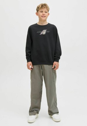 Svart sweatshirt med en grafisk logotyp, kombinerad med löst sittande grå cargobyxor och vita sneakers. Enkel design, avslappnad tygtextur.