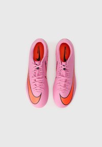 Bottes de football Nike Mercurial en rose vif avec des accents noirs et orange, présentant une surface texturée et un design épuré.