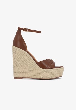 Sandale compensée en cuir marron avec bride à la cheville et boucle, dotée d'une semelle plateforme haute en fibres naturelles tressées.