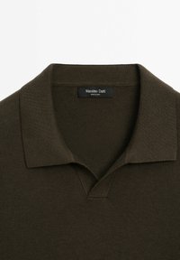 Polo en maille vert olive foncé avec col ouvert et étiquette "Massimo Dutti" à l'intérieur du col.