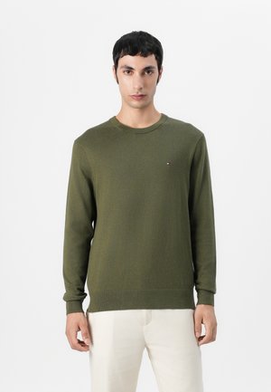 Pulover tricotat de culoare verde măslin, cu guler rotund, mâneci lungi, manșete și tiv din țesătură în dungi, având un mic logo pe piept.