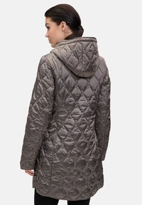Kurtka dla kobiet w kolorze szarym, pikowana, z kapturem, charakteryzująca się błyszczącym wykończeniem, wzorem w diamenty oraz zamknięciem na zatrzaski z boku.