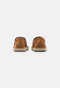 Brown suede espadrilles with a braided jute sole, open back design, and subtle stitching detail along the edges.