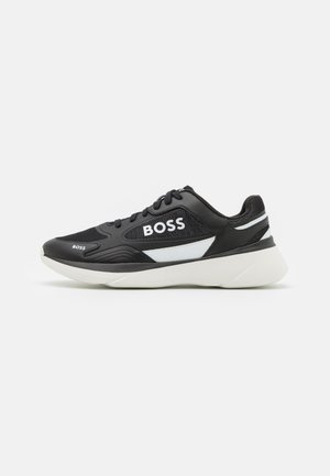 Sort og hvid BOSS sneaker med tyk hvid sål, snørebånd foran og BOSS logoer på siden og tåområdet.