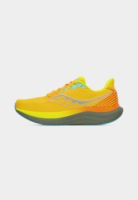 Φωτεινό κίτρινο και πορτοκαλί παπούτσι για τρέξιμο με χοντρή γκρι σόλα, μπλε λεπτομέρειες και λογότυπο της μάρκας στο πλάι, εμφανισμένο σε προφίλ σε λευκό φόντο.