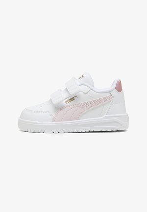 Białe dziecięce buty Puma z jasnoróżowym paskiem, złotym logo, podwójnym zapięciem na rzepy i różowym akcentem na pięcie, na jednolitym tle.