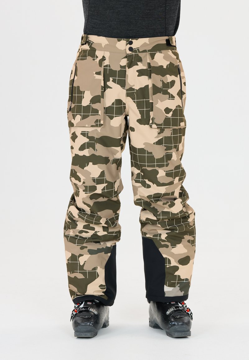 Camouflage skibroek in beige en groen met een ruitpatroon, voorzien van meerdere zakken en een zwarte accenten bij de boorden.