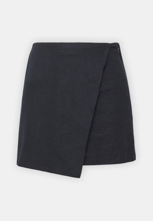 Jupe enveloppante en lin bleu marine avec une fermeture éclair sur le côté, des lignes épurées et un ourlet légèrement asymétrique pour un design moderne.