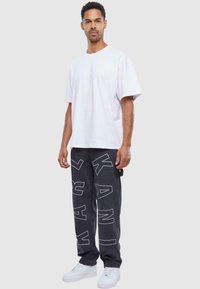 Karl Kani OG GY WOREAR LOGO PRINT DENIM - Traperice ravnih nogavica - bleached black