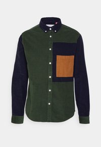 Viskoseskjorta med gröna och marinblå paneler, med ett brunt ficklock. Knappkrage, långa ärmar och textilstruktur.