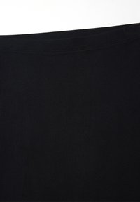 Tessuto di cotone nero con una consistenza liscia, caratterizzato da un bordo diritto e cuciture lungo la parte superiore. Senza motivi o disegni visibili.