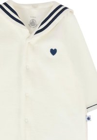 Body bianco in cotone con colletto da marinaio caratterizzato da strisce navy e un piccolo cuore navy ricamato sul petto. Chiusure a pressione sul davanti.