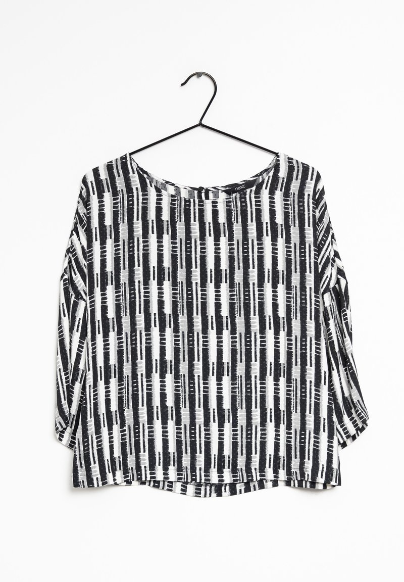 Blouse à motifs noir et blanc avec une coupe fluide, un col rond et des manches larges. Le tissu présente des rayures verticales et des détails de coups de pinceau abstraits.