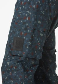 Patronen cargobroek in een donkerblauwe stof, met onregelmatige meerkleurige vormen, een zijzak en een zwart logo-opdruk.