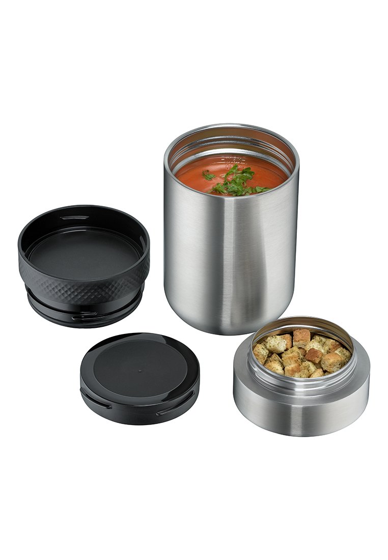 Pojemnik na żywność ze stali nierdzewnej z wykończeniem w kolorze srebrnym, czarną pokrywką i osobną przegrodą na grzanki. Zawiera zupę i zioła.