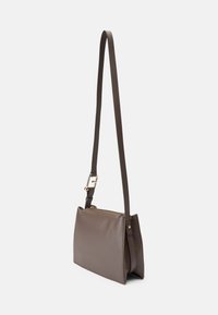 Hnědá kožená crossbody taška s texturovaným povrchem, zlatými detaily, nastavitelným popruhem a zipovým uzávěrem. Obdélníkový tvar s ostrými hranami.