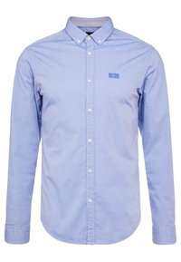 Světle modrá košile na knoflíky z bavlněné směsi, s malým modrým logem na hrudi, dlouhými rukávy a špičatým límcem.
