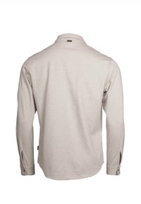Chemise beige à manches longues vue de dos avec poignets boutonnés et une petite étiquette noire près du col.