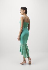 Rochie turquoise cu un corset din dantelă și o margine din dantelă evazată. Textură de țesătură fină, bretele subțiri și un siluetă ajustată. Design elegant.